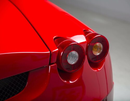 A closeup shot of the headlights of a modern red car