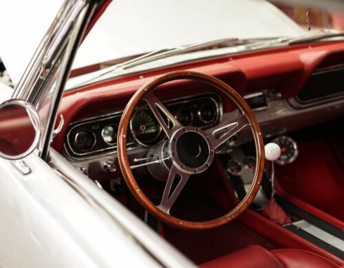 A high angle closeup shot of a white retro car with a beautiful steering wheel - great for an article about retro cars